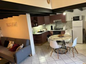 a kitchen and living room with a couch and a table at maisonnette bord de mer in Royan