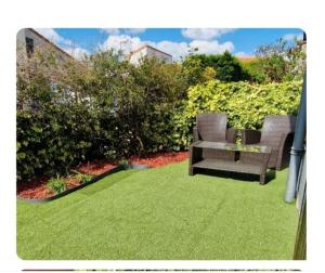 two chairs and a table in a yard with green grass at maisonnette bord de mer in Royan