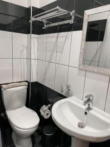 ein Badezimmer mit weißer Toilette und Waschbecken in der Unterkunft Kleanthi`s Hotel in Himarë