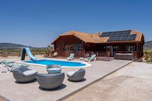 a house with a pool and some chairs and a building at Rustic Villa Retreat in Pinoso