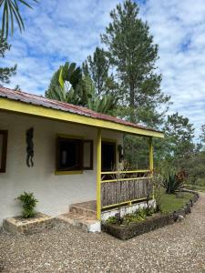 a small yellow house with a fence in front of it at Pine Ridge Lodge Belize in San Ignacio