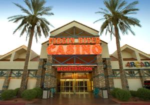a hotel with palm trees in front of it at Virgin River Casino and Lodge in Mesquite