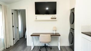 a home office with a desk and a television on a wall at Peace Barn Getaway in Carrollton
