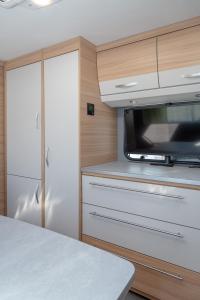 a kitchen with a white counter and a microwave at Wohnwagenvermietung Sylt in Rantum