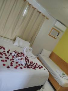 a bedroom with a bed with roses on it at Pousada Mayer in Paulo Afonso