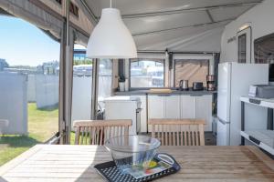 a kitchen and dining table in an rv at Wohnwagenvermietung Sylt in Rantum +19 photos