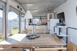 a kitchen and dining room with a wooden table in a caravan at Wohnwagenvermietung Sylt in Rantum