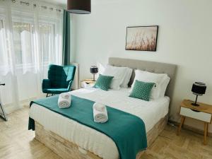 a bedroom with a large bed with a blue chair at Appartement Spacieux au Port de Nice avec Clim et Parking Gratuit in Nice