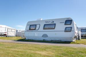 a white camper parked in a parking lot at Wohnwagenvermietung Sylt in Rantum