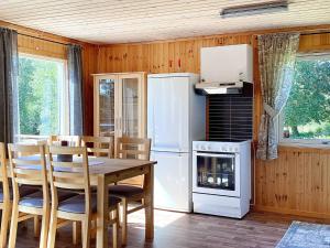 a kitchen with a table and a refrigerator and a stove at 4 person holiday home in BENGTSFORS in Bengtsfors +19 photos