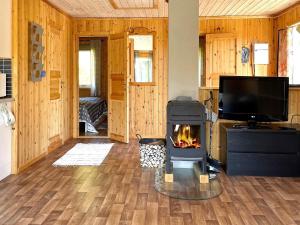 a living room with a fireplace and a television at 4 person holiday home in BENGTSFORS in Bengtsfors