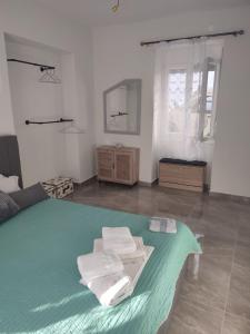 a bedroom with a large bed with towels on it at Το σπιτι στη Ρουγα in Glossa
