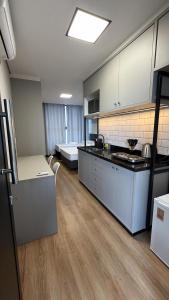 a kitchen with a stove and a bed in a room at Residencial Roberto Luiz Chiodi in Campos Novos