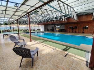 a swimming pool with two chairs in a building at Hospedaje Centro Huequén in Angol