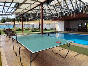 a ping pong table in front of a swimming pool at Hospedaje Centro Huequén in Angol