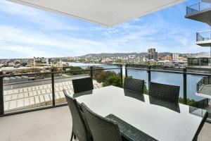 um apartamento varanda com uma mesa branca e cadeiras em Spice Apartments by CLLIX em Brisbane