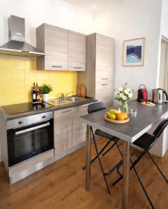 a kitchen with a table with a bowl of fruit on it at Appartement Marseille au cœur du panier in Marseille +9 photos