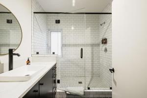 a white bathroom with a sink and a shower at Noon on Sunset Hill in Los Angeles
