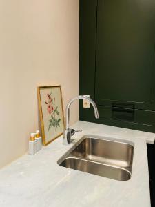 a kitchen counter with a sink and a painting at Alcazar in Mechelen +36 photos