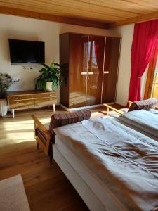a bedroom with two beds and a flat screen tv at Haus Rosi in Uttendorf