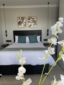 a bedroom with a bed and some white flowers at Black Rose Guesthouse Northam in Northam