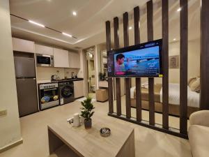 a living room with a large television in a bedroom at ذا سهل ستيز in Amman