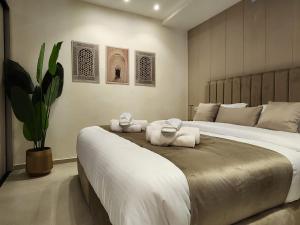 a bedroom with a large bed with towels on it at ذا سهل ستيز in Amman