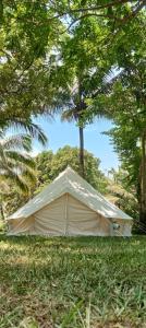 a tent in the grass with trees in the background at Campo De Laiya in San Juan