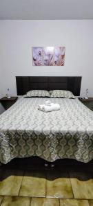 a bed with a blanket on top of it at Habitaflex Casa No Centro de Urupês in Urupês