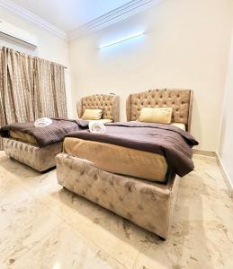 a bedroom with two beds and a couch at Dar E Noor in Hyderabad