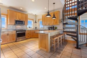 a kitchen with wooden cabinets and a spiral staircase at 8650 - Mare Vista Retreat in Frisco