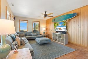 a living room with a couch and a surfboard on the wall at 8650 - Mare Vista Retreat in Frisco