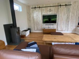 a living room with a couch and a flat screen tv at Cranbrook on the river lym walk in Uplyme in Uplyme