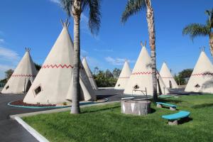 Une bande de tentes blanches avec des palmiers dans l'établissement Wigwam Motel, à San Bernardino