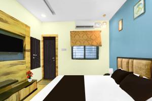 a bedroom with a bed and a flat screen tv at Super Collection O ISKCON Radha Govind Formerly Hotel Shivom in Indore