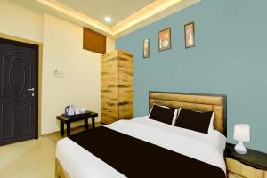 a bedroom with a large bed and a black door at Super Collection O ISKCON Radha Govind Formerly Hotel Shivom in Indore
