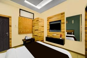 a bedroom with a large bed and a television at Super Collection O ISKCON Radha Govind Formerly Hotel Shivom in Indore +46 photos