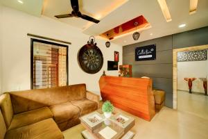 a living room with a couch and a clock on the wall at Super Collection O ISKCON Radha Govind Formerly Hotel Shivom in Indore