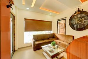 a living room with a couch and a large clock at Super Collection O ISKCON Radha Govind Formerly Hotel Shivom in Indore