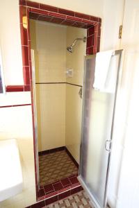 une douche avec une porte vitrée dans une salle de bain dans l'établissement Wigwam Motel, à San Bernardino