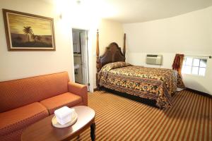 une chambre d'hôtel avec un lit et un canapé dans l'établissement Wigwam Motel, à San Bernardino 22 autres photos