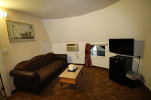 un salon avec un canapé et une télévision à écran plat dans l'établissement Wigwam Motel, à San Bernardino