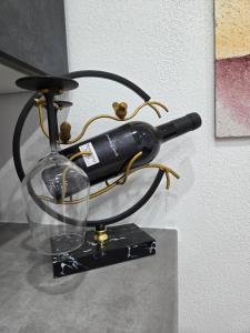 a wine bottle and a glass on a stand at Kings Apartments in Ingolstadt