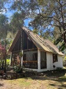 a small white house with a gambrel roof at Pine Ridge Lodge Belize in San Ignacio