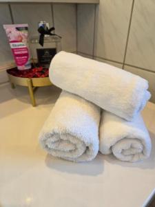 a stack of towels sitting on a counter in a bathroom at Kings Apartments in Ingolstadt