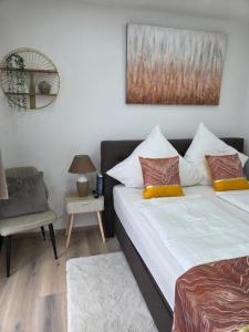 a bedroom with two beds and a chair at Kings Apartments in Ingolstadt