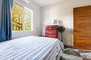 a bedroom with a bed and a window and a dresser at Oz Residence Beach Two-Bedroom Apartment & Free Parking in Los Botados