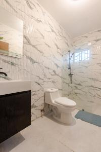 a bathroom with a toilet and a sink at Oz Residence Beach Two-Bedroom Apartment & Free Parking in Los Botados +32 photos