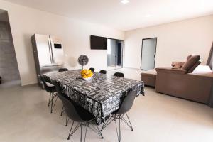 a dining room with a table with chairs and a couch at Casa grande alto padrão á 100 metros do mar in Guaratuba