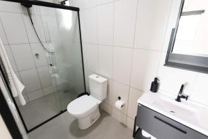 a bathroom with a toilet and a shower and a sink at Casa grande alto padrão á 100 metros do mar in Guaratuba +11 photos